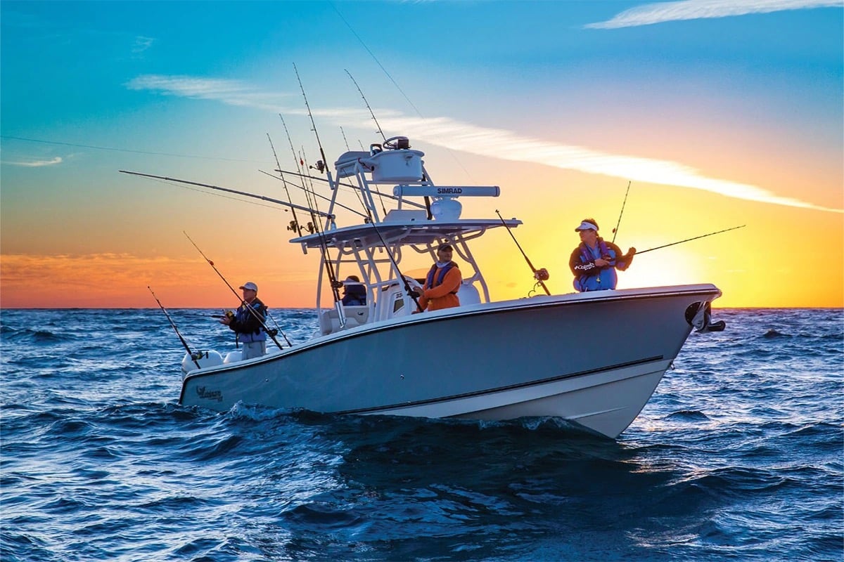 At sunset, two men fish from a boat, experiencing world-class fishing in a serene and beautiful setting. 