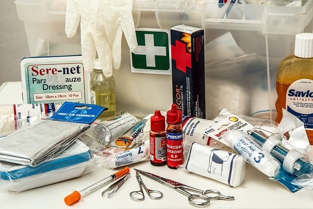 Pack filled with essential items, prominently featuring a first aid kit for emergency preparedness. 