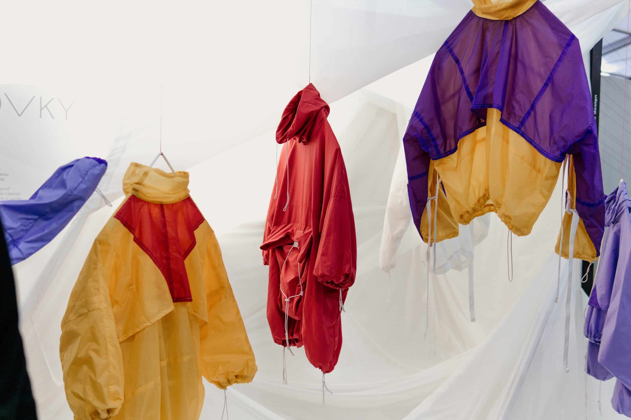 A collection of bright, colorful jackets hanging on a line, creating a lively and cheerful visual display as an example of weather-appropriate clothing.